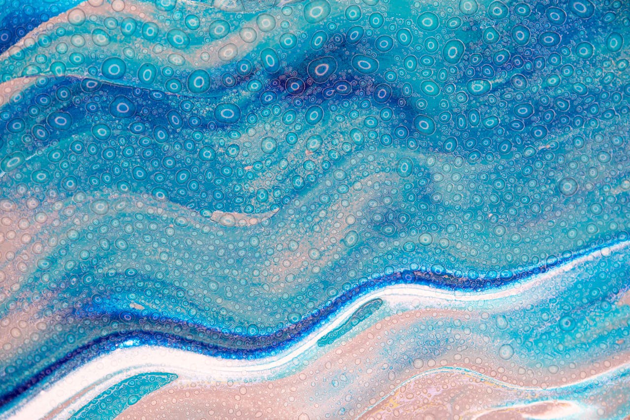 Dynamic abstract art featuring swirling blue and pink textures with circular patterns.